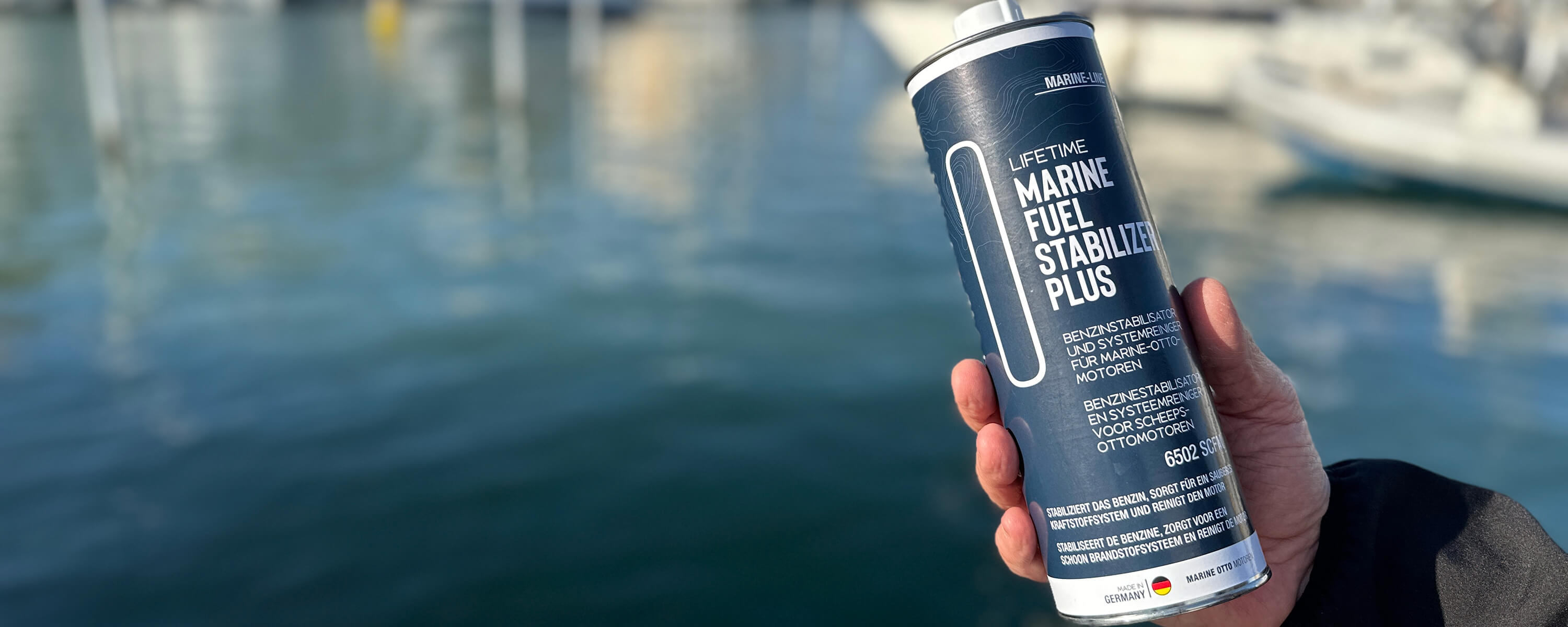 Eine Männerhand hält das Produkt Lifetime Marine Fuel Stabilizer Plus.