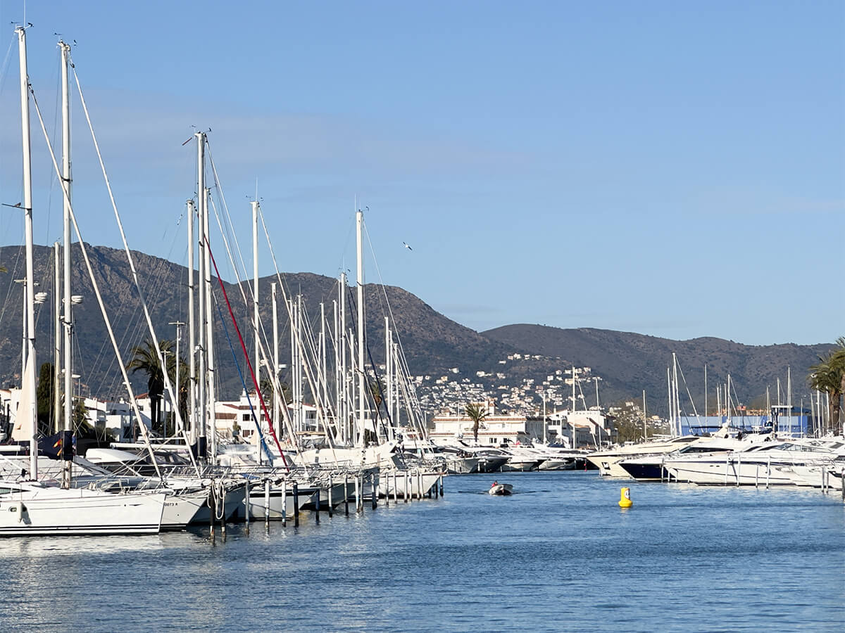 Ein mediterraner Yachthafen mit vielen weißen Yachten. Berge am Horizont. Optimierte Bildgröße für Mobile-Ansicht.