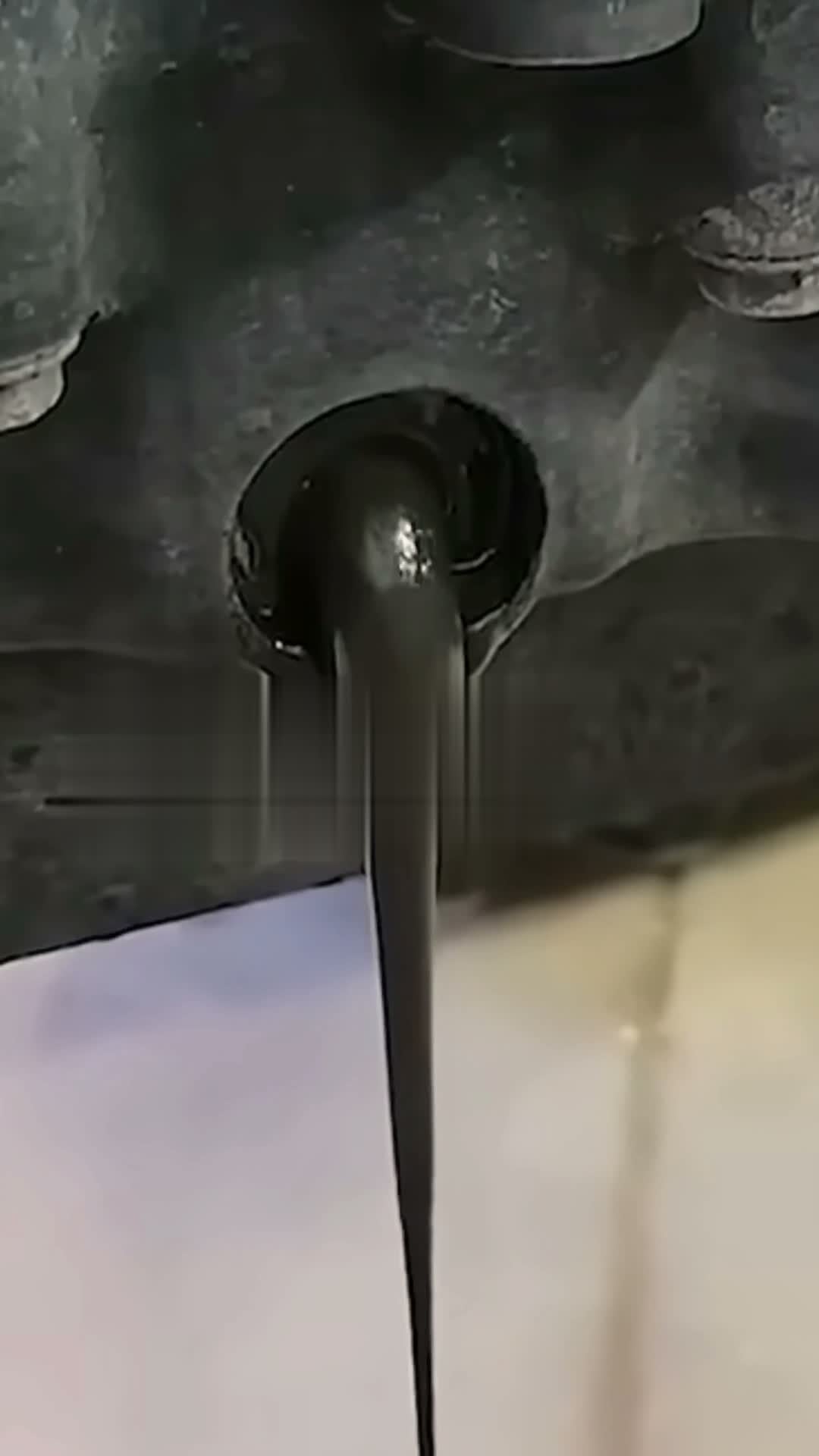 Schwarzes verschlammtes Altöl läuft aus der Ölablassschraube, klassisches Bild bei Turbo-Vorschäden